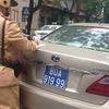 Lực lượng chức năng đã tiến hành lập biên bản tạm giữ chiếc xe Lexus tiền tỷ. (Ảnh: PV/Vietnam+)