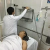 Thượng úy Nguyễn Quốc Đạt đang trong tình trạng bị chấn thương nặng, khó thở. Các bác sỹ đa khoa đang tiến hành đưa đi chụp chiếu. (Ảnh: PV/Vietnam+)