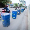 Những chiếc thùng phuy được làm thành dải phân cách giúp người đi đường 'dễ dàng' đi lại, nhất là vào giờ cao điểm. (Ảnh: Minh Sơn/Vietnam+)