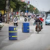 Những chiếc thùng phuy thình lình xuất hiện tại tuyến đường từ Nhổn đến Cầu Diễn làm người tham gia giao thông bất ngờ. (Ảnh: Minh Sơn/Vietnam+)