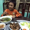 Bé trai được ăn cơm tại trụ sở đội Cảnh sát giao thông số 8. (Ảnh: PV/Vietnam+)