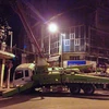 Chiếc xe cẩu bơm bê tông bất ngờ đổ nghiêng khi đang thi công khiến nhiều người dân hốt hoảng. (Ảnh: PV/Vietnam+)