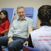 Trong khi nằm nghỉ sau khi hiến máu, Đại sứ Ted Osius tươi cười trò chuyện với một nhân viên y tế. (Ảnh: Minh Sơn/Vietnam+)