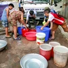 Sau khi nguồn nước sạch bị mất được 9 ngày, rất nhiều hộ dân đã được 'giải cứu' bằng một xe bồn chở nước sạch của công ty cấp nước Hà Nội. (Ảnh: Minh Sơn/Vietnam+)