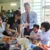Đại sứ Mỹ hào hứng làm bánh nướng, bánh dẻo cùng các em nhỏ nạn nhân chất độc da cam dioxin. (Ảnh: Minh Sơn/Vietnam+)