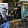 Một người đàn ông nghiêm trang đặt hoa cạnh bức ảnh nhà lãnh tụ vĩ đại Fidel Castro. (Ảnh: Minh Sơn/Vietnam+)