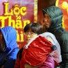 Chị Hương (Vĩnh Tuy, Hà Nội) cùng con trai 15 tháng tuổi của mình dắt díu nhau xếp hàng từ 5 giờ sáng để mua vàng nhân ngày Thần Tài (mùng 10 tháng Giêng Âm lịch). (Ảnh: Minh Sơn/Vietnam+)