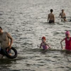 Trong những ngày nắng nóng đỉnh điểm ở Hà Nội, cứ vào tầm chiều muộn thời tiết mát mẻ, nhiều người dân đã kéo nhau ra khu vực hồ Tây để tắm giải nhiệt. (Ảnh: Minh Sơn/Vetnam+) 