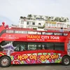 Sáng 30/5, 3 chiếc xe buýt 2 tầng, mui trần màu đỏ phục vụ du lịch đã chính thức được lăn bánh trong sự chờ đón của rất nhiều người dân Thủ đô. (Ảnh: PV/Vietnam+) 