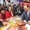 Thủ tướng Nguyễn Xuân Phúc thăm gian trưng bày của Liên Chi hội Nhà báo Thông tấn xã Việt Nam. (Ảnh: TTXVN)