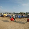 Dù mỗi ngày chịu tới 6 tấn rác thải nhưng chỉ sau một đêm, 4km bờ biển Bãi Cháy (Quảng Ninh) lại trở nên sạch đẹp, trắng tinh phơi mình đón nắng… Đó là nhờ công sức cần mẫn của đội nữ công nhân vệ sinh môi trường. (Ảnh: Vietnam+)