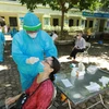 Nhân viên y tế lấy mẫu xét nghiệm cho người dân phường Nghĩa Đô. (Ảnh: Vũ Sinh/TTXVN)