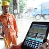 Công nhân Công ty Điện lực Sóc Sơn thuộc Tổng Công ty Điện lực Hà Nội ghi chỉ số côngtơ khách hàng trên địa bàn bằng thiết bị mới. (Ảnh: Ngọc Hà/TTXVN)