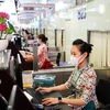 Các quầy làm thủ tục tại sân bay Nội Bài đã ngay lập tức triển khai cho nhân viên Vietnam Airlines đeo khẩu trang khi làm nhiệm vụ. (Ảnh: CTV/Vietnam+).