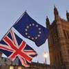 Cờ Anh (phía dưới) và cờ EU (phía trên) bên ngoài tòa nhà Quốc hội ở thủ đô London (Anh). (Ảnh: AFP/TTXVN)