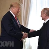 Tổng thống Nga Vladimir Putin (phải) trong cuộc gặp Tổng thống Mỹ Donald Trump (thứ 2, trái) tại Helsinki, Phần Lan ngày 16/7/2018. (Ảnh: AFP/ TTXVN)