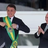 Tổng thống mãn nhiệm của Brazil Michel Temer (phải) trao khăn choàng biểu tượng cho Tổng thống đắc cử Jair Bolsonaro (trái) tại lễ tuyên thệ nhậm chức ở Brasilia ngày 1/1/2019. (Nguồn: THX/TTXVN)