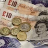 Tiền giấy mệnh giá 10 và 20 bảng Anh cùng với tiền xu 1 và 2 bảng Anh tại Liverpool. (Nguồn: AFP/ TTXVN)