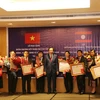 Bộ trưởng Bộ Lao động-Thương binh và Xã hội Việt Nam Đào Ngọc Dung trao tặng Huân chương Hữu nghị cho tập thể của Bộ Lao động và Phúc lợi xã hội Lào. (Nguồn: Xuân Tú/TTXVN)