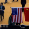 Cờ Mỹ (trái) và cờ Trung Quốc (phải) tại một gian hàng ở Triển lãm nhập khẩu quốc tế Trung Quốc. (Ảnh: AFP/ TTXVN) 