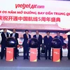 Thủ tướng Nguyễn Xuân Phúc và các đại biểu thực hiện nghi thức kỷ niệm 05 năm Vietjet Air mở đường bay tới Trung Quốc. (Ảnh: Thống Nhất/TTXVN)