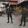 Lực lượng an ninh Sri Lanka gác bên ngoài một cửa hàng bị đập phá trong vụ đụng độ nhằm vào người Hồi giáo ở Minuwangoda ngày 14/5. (Ảnh: AFP/TTXVN)