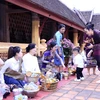 Cả gia đình đủ các thế hệ đang chờ đến lượt để thực hiện để thực hiện các nghi thức tôn giáo trong Bun Okphansa. (Ảnh: Phạm Kiên/TTXVN)