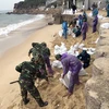Lực lượng vũ trang tại tỉnh Bình Định xúc cát giúp người dân xã Nhơn Hải, TP Quy Nhơn gia cố nhà cửa chống bão số 6. (Ảnh: Nguyên Linh/TTXVN)