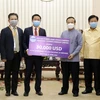 Ông Đinh Ngọc Diệp, Trưởng Đại diện Công ty CP điện Việt Lào (trái) và Phó Thủ tướng, Bộ trưởng Tài chính Lào Somdy Duangdy (Phải) tại lễ trao tiền ủng hộ. (Ảnh: PV/TTXVN)