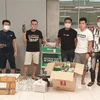 Nhóm công dân Việt Nam bị mắc kẹt tại sân bay Survanabhumi tiếp nhận thức ăn và đồ dùng thiết yếu do cán bộ Đại sứ quán chuyển đến. (Ảnh: TTXVN)