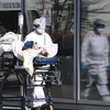 Nhân viên y tế tại Pháp đưa người nhiệm bệnh vào viện. (Ảnh: France24)