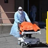 Nhân viên y tế tại Mỹ vận chuyển một thi thể bệnh nhân tử vong vì dịch COVID-19. (Ảnh: The Independent)