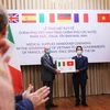 Thừa uỷ quyền của Thủ tướng Chính phủ, Thứ trưởng Bộ Ngoại giao Tô Anh Dũng trao hàng hỗ trợ của Việt Nam đến Đại sứ Italy tại Việt Nam Antonio Alessandro. (Ảnh: Lâm Khánh – TTXVN)