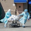 Nhân viên y tế chuyển thi thể bệnh nhân COVID-19 tới nhà xác dã chiến của bệnh viện Wyckoff ở Brooklyn, New York, Mỹ. (Ảnh: AFP/TTXVN)