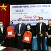 Ông Cho Han-Deok, Giám đốc quốc gia KOICA Việt Nam (thứ tư từ trái sang) trao quà cho phụ nữ có hoàn cảnh khó khăn tại Hà Nội. Ảnh: TTXVN