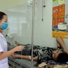 Nhân viên y tế tại Trạm Y tế xã Chiềng Cọ điều trị cho các học sinh nghi ngộ độc thực phẩm. (Ảnh: TTXVN)