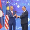 Thủ tướng Nguyễn Xuân Phúc trao chiếc búa gỗ cho Đại sứ Brunei tại Việt Nam-nước giữ vai trò Chủ tịch ASEAN 2021. (Ảnh: Doãn Tấn/TTXVN)