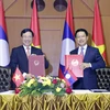 Phó Thủ tướng, Bộ trưởng Ngoại giao Phạm Bình Minh (trái) và Bộ trưởng Ngoại giao Lào Saleumsay Kommasith đang trao cho nhau Thỏa thuận hợp tác giữa Bộ Ngoại giao Việt Nam và Bộ Ngoại giao Lào giai đoạn 2021-2025. (Ảnh: Phạm Kiên/TTXVN)