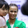 Vận động viên Tô Thị Trang hạnh phúc bên gia đình sau khi giành huy chương vàng. (Ảnh: PV/Vietnam+) 