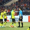 Cầu thủ Malaysia phân trần với trọng tài về tình huống phạm lỗi với Đoàn Văn Hậu. (Ảnh: PV/Vietnam+) 