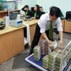 Cán bộ Vietcombank đang sắp xếp tiền để nạp cho cây ATM. (Nguồn: Vietcombank)