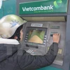 Khách hàng rút tiền tại ATM Vietcombank. (Nguồn: TTXVN)