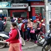 Người dân xếp hàng chờ rút tiền tại cây ATM trên đường Hòa Lạc. (Ảnh: Ngọc Hà: TTXVN)