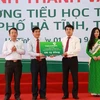 Ông Nghiêm Xuân Thành, Chủ tịch HĐQT Vietcombank (thứ 2 từ phải sang) trao tượng trưng số tiền 6 tỷ đồng xây dựng Trường tiểu học Trần Phú (Hà Tĩnh). (Nguồn: Vietcombank)