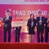 Khách hàng Lê Thị Thơi nhận sổ tiết kiệm 1 tỷ đồng giải đặc biệt từ lãnh đạo Agribank. (Nguồn: Agribank)