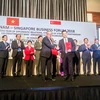 Đại diện Vietcombank, ông Phạm Quang Dũng, Tổng Giám đốc (hàng đầu, bên phải) và đại diện SBF, ông Ho Meng Kit – Giám đốc điều hành ký kết thỏa thuận hợp tác giữa hai bên. (Nguồn: Vietcombank)