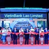 Các đại biểu cắt băng khai trương trụ sở VietinBank Lào. (Ảnh: Phạm Kiên/Vietnam+)