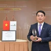 Chủ tịch Vietcombank Nghiêm Xuân Thành nhận danh hiệu "Lãnh đạo xuất sắc trong việc ứng phó với đại dịch COVID-19 tại Việt Nam” do The Asian Banker trao tặng. (Ảnh: Vietnam+)