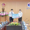 Ông Lê Đức Thọ - Chủ tịch Hội đồng quản trị VietinBank (bên phải) trao tặng 25 tỷ đồng hỗ trợ mua vaccine phòng COVID-19. (Ảnh: Vietnam+)