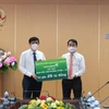 Ông Nghiêm Xuân Thành, Chủ tịch HĐQT Vietcombank (bên phải) trao biển tượng trưng số tiền 25 tỷ đồng hỗ trợ Bộ Y tế mua vaccine. (Ảnh: Vietnam+)